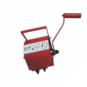 um pequeno guincho manual com alavanca latera na cor vermelha com alça na parte superior